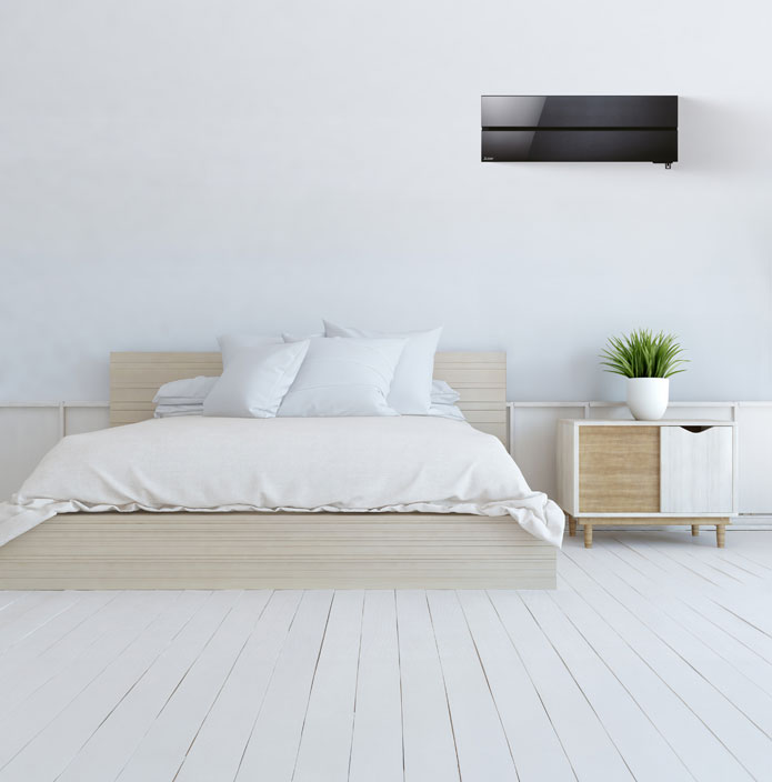 Chambre moderne et épurée avec un lit en bois clair, un climatiseur mural noir au-dessus du lit et une table de chevet avec une plante verte.